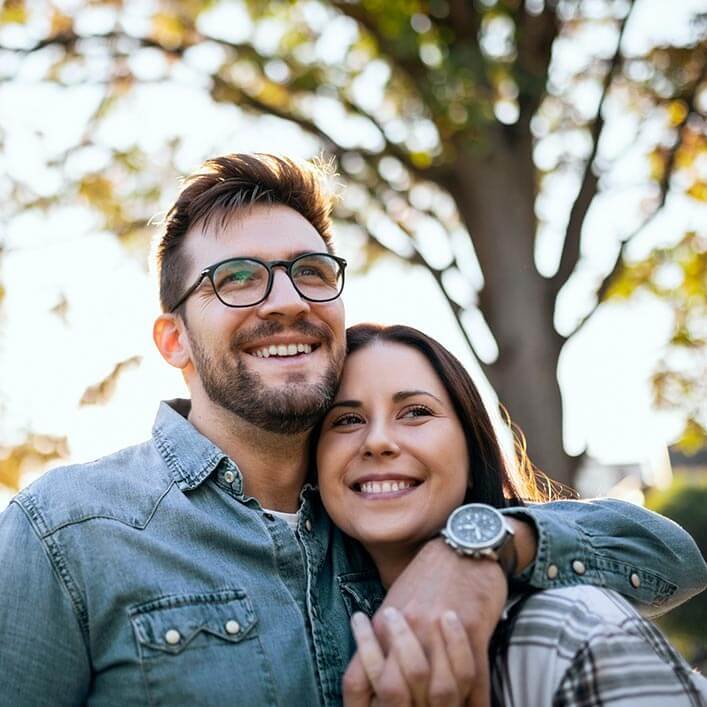 smiling young couple with tree background