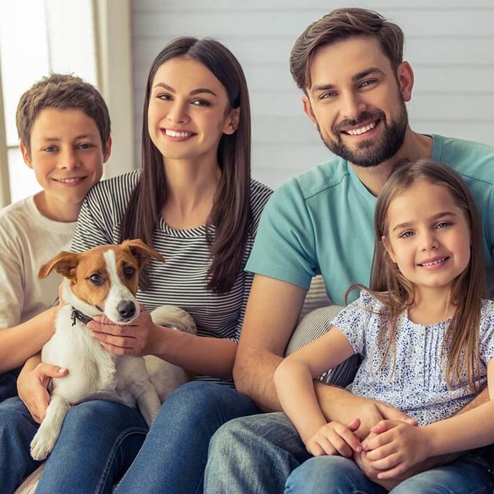 husband and wife enjoying family time with their son, faughter and pet dog