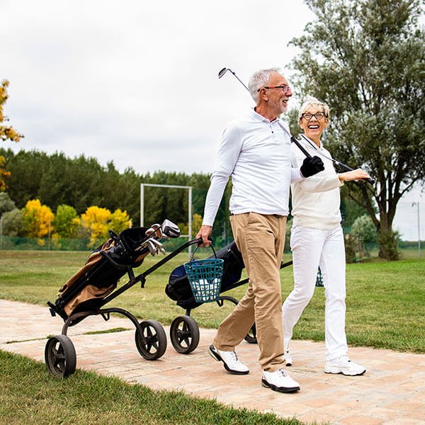 elderly couple walking in a golf park
